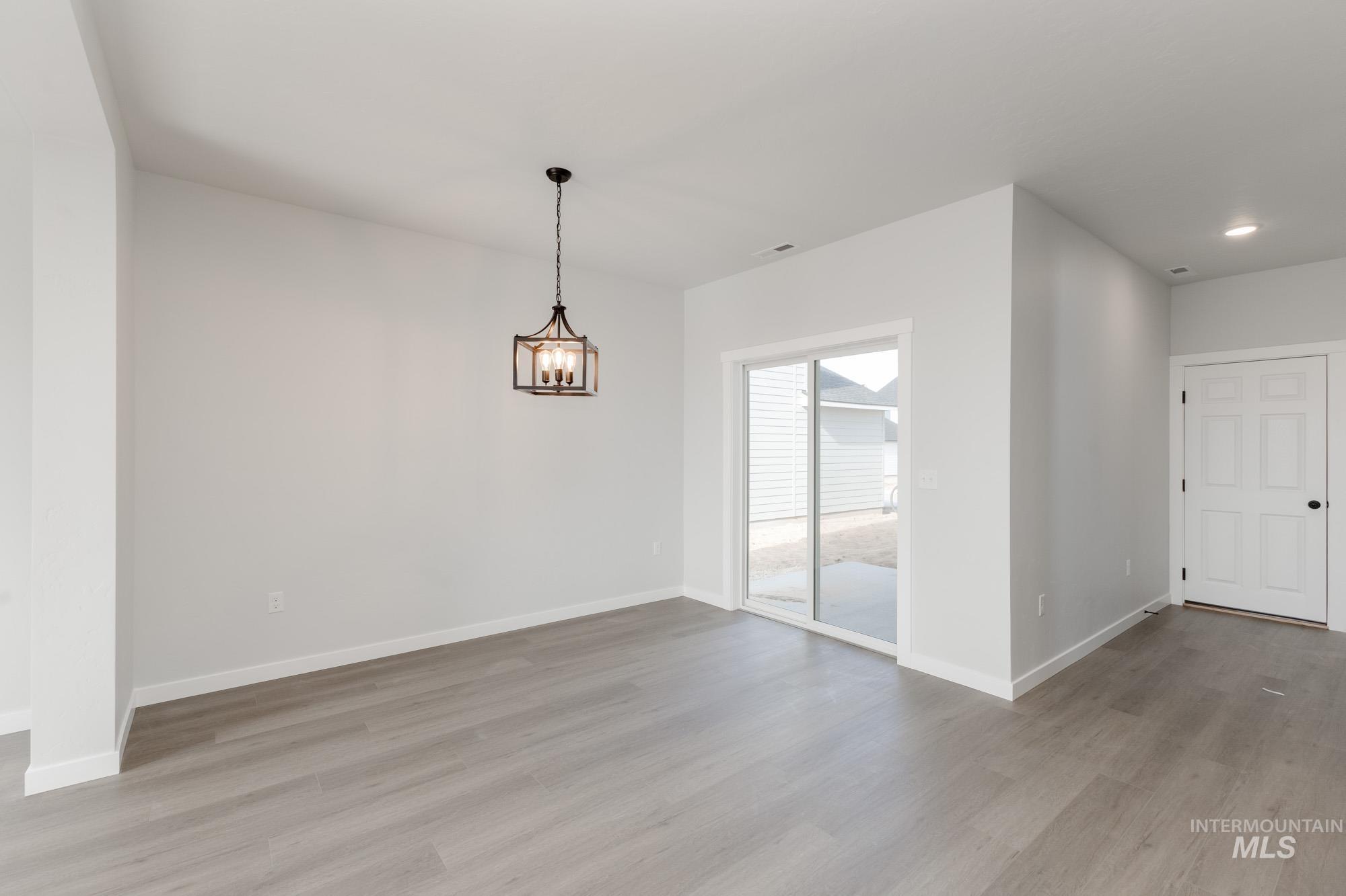 Unfurnished dining area with light wood-type flooring, a chandelier, and recessed lighting