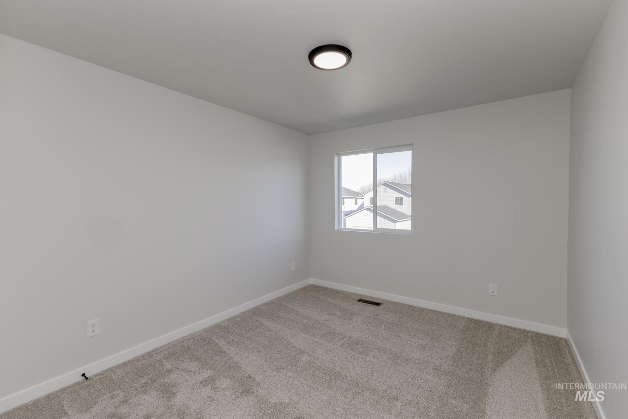 Carpeted empty room featuring baseboards