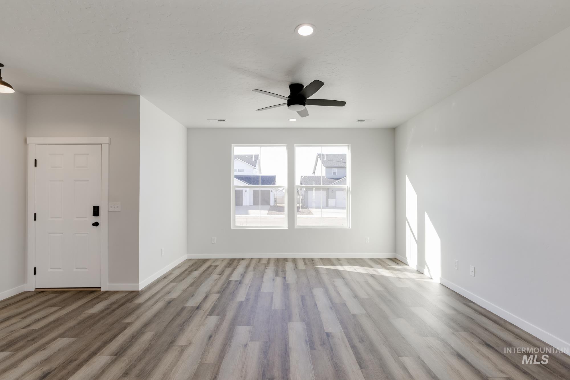 Unfurnished living room with a ceiling fan, recessed lighting, and light wood-style floors