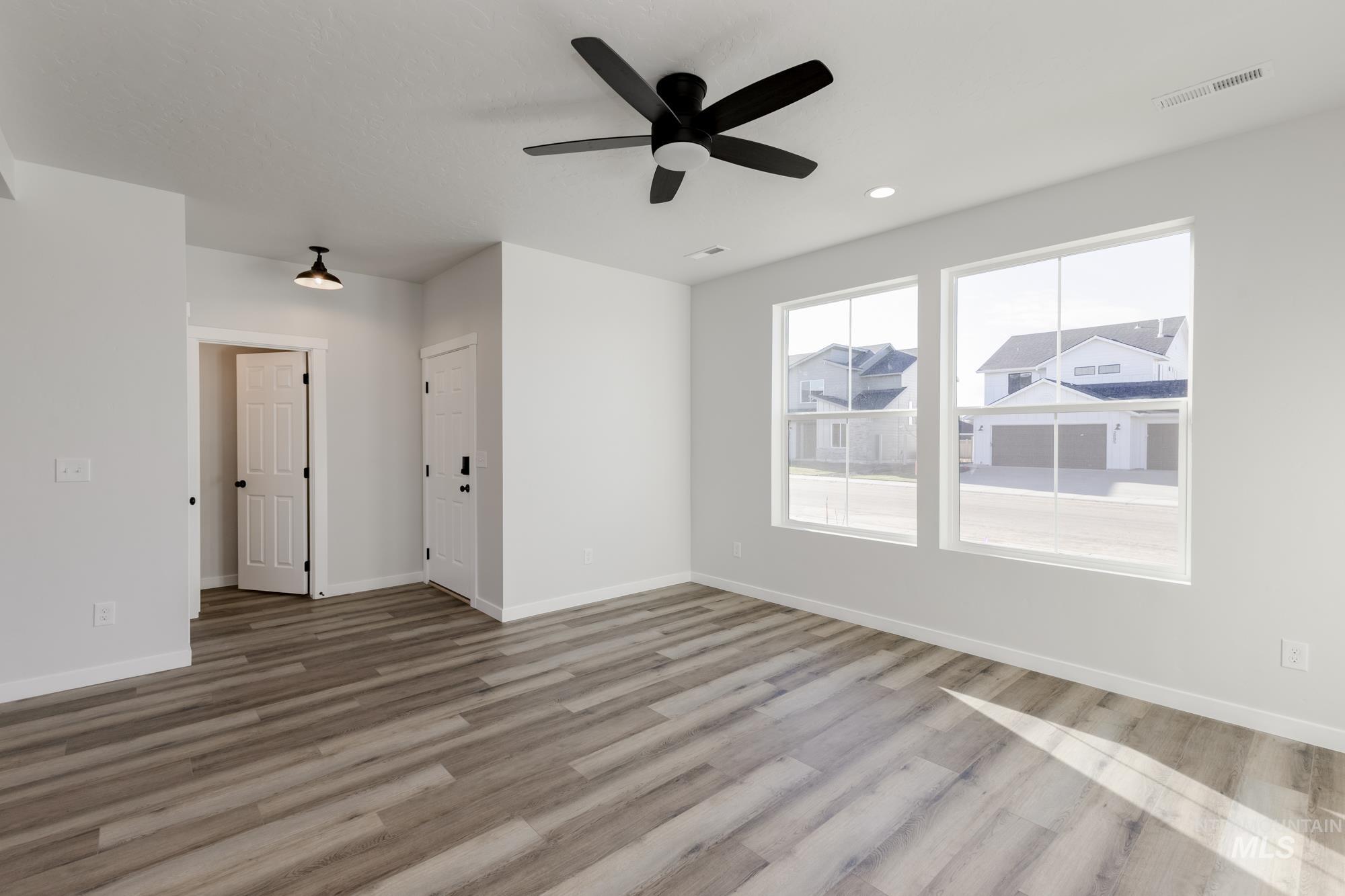 Empty room featuring light wood-style flooring, ceiling fan, and recessed lighting