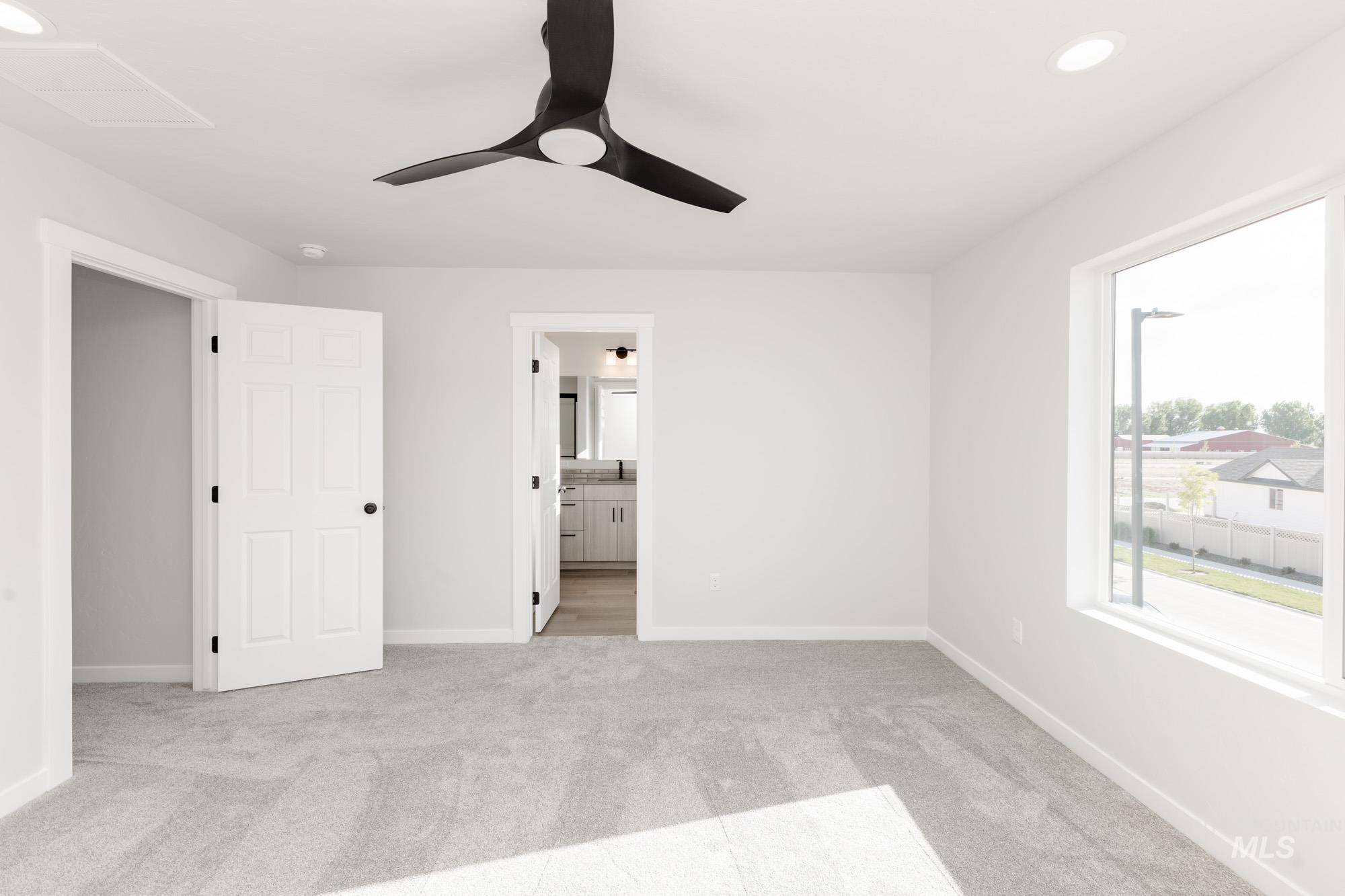 Unfurnished bedroom with light colored carpet, recessed lighting, connected bathroom, and a ceiling fan