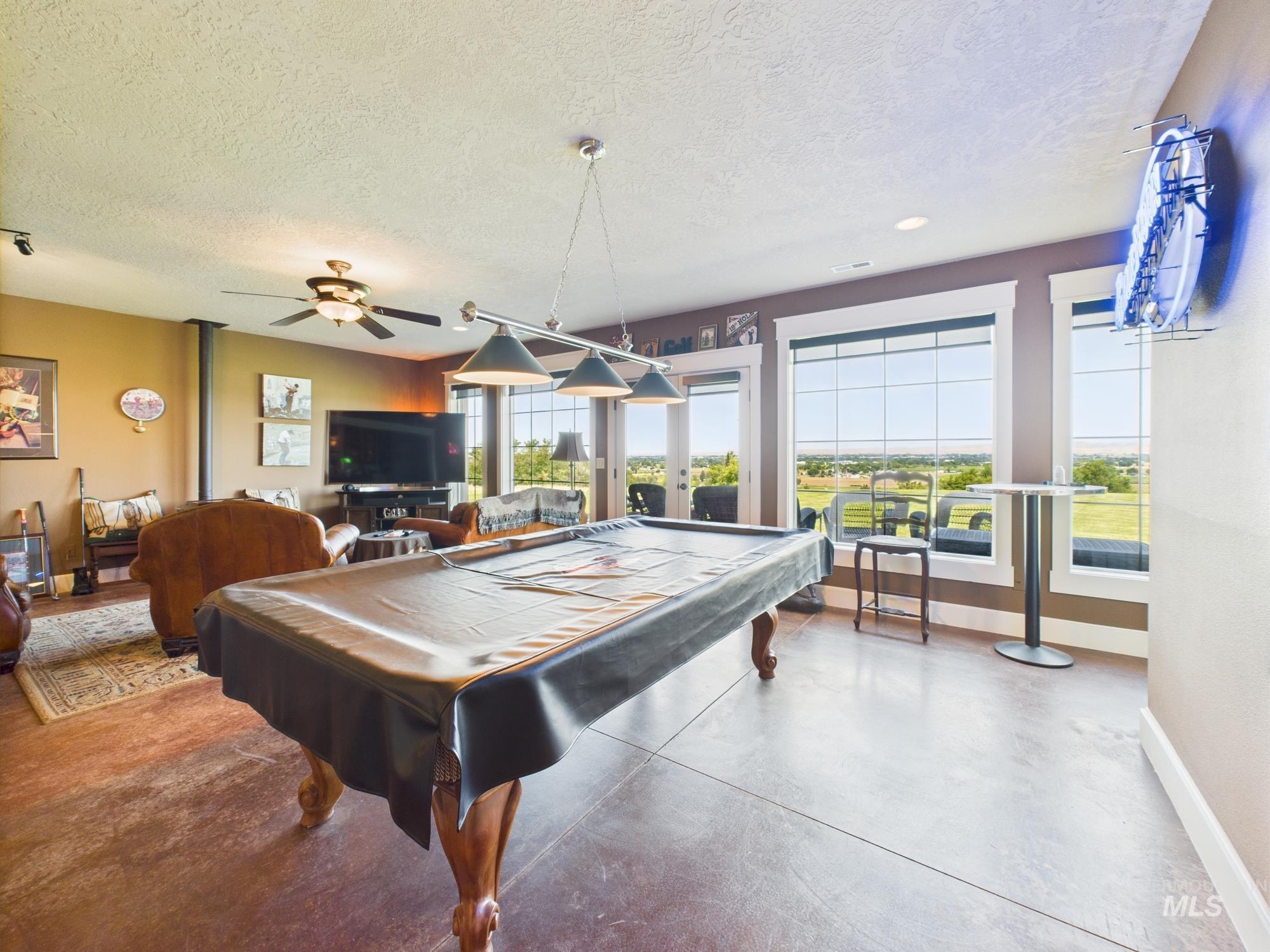 Game room featuring french doors, concrete floors, a textured ceiling, and pool table