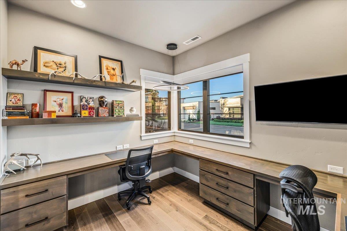 Office space featuring built in study area, light wood-style floors, and recessed lighting