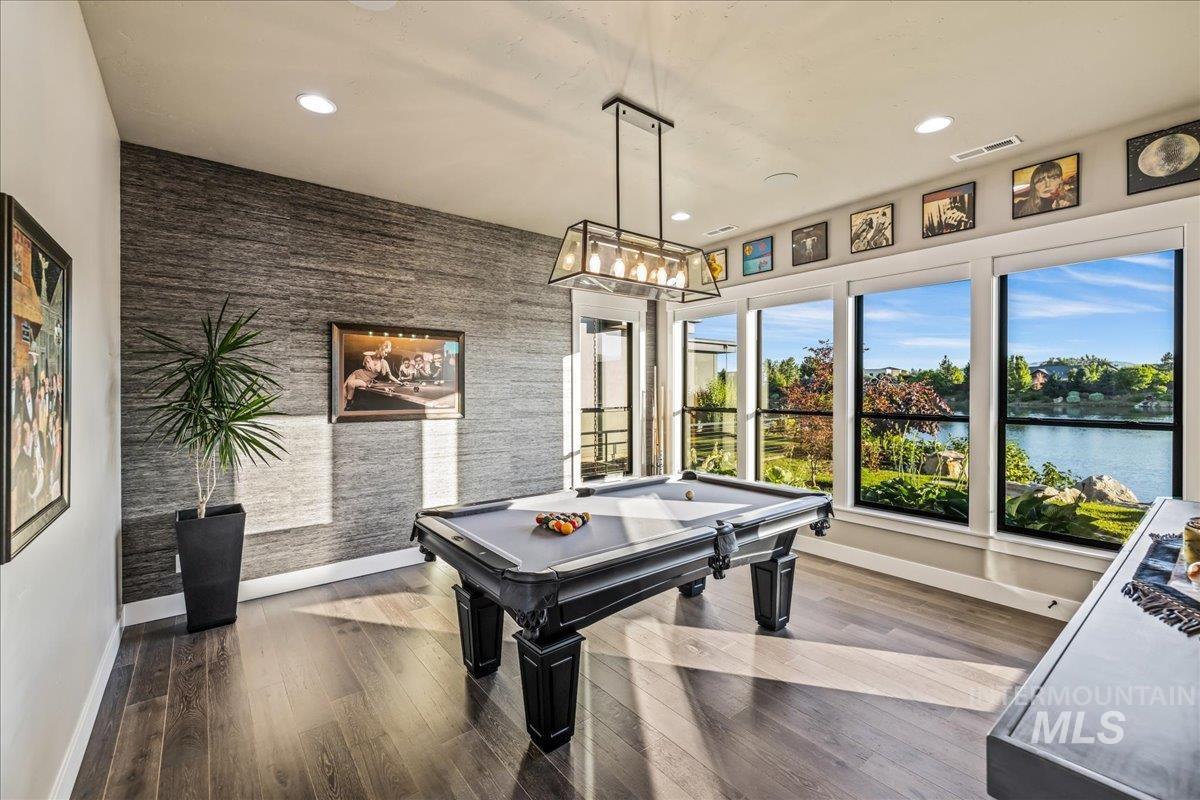 Recreation room with pool table, a water view, recessed lighting, and wood finished floors