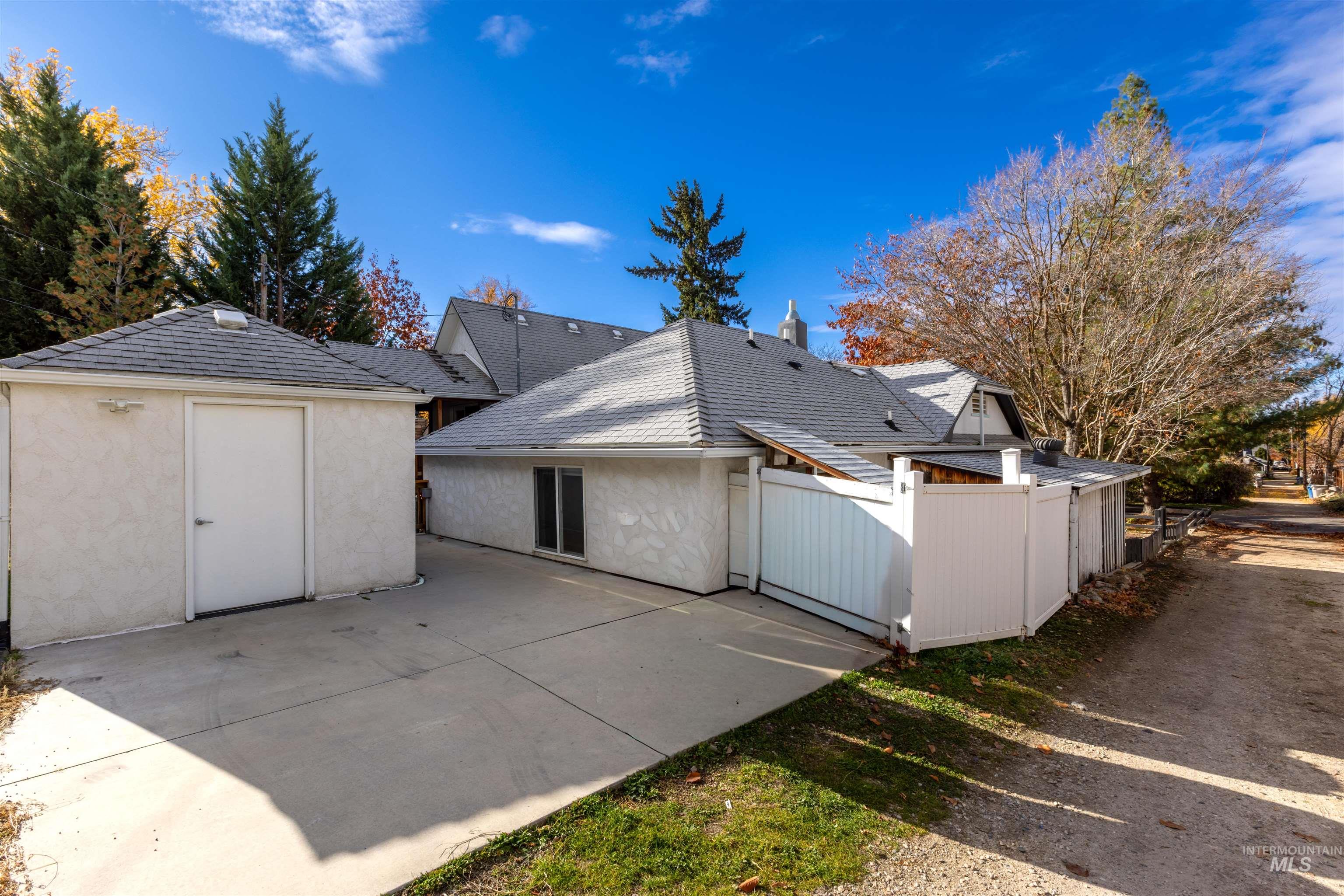 Rear view of property featuring an outdoor structure and stucco siding
