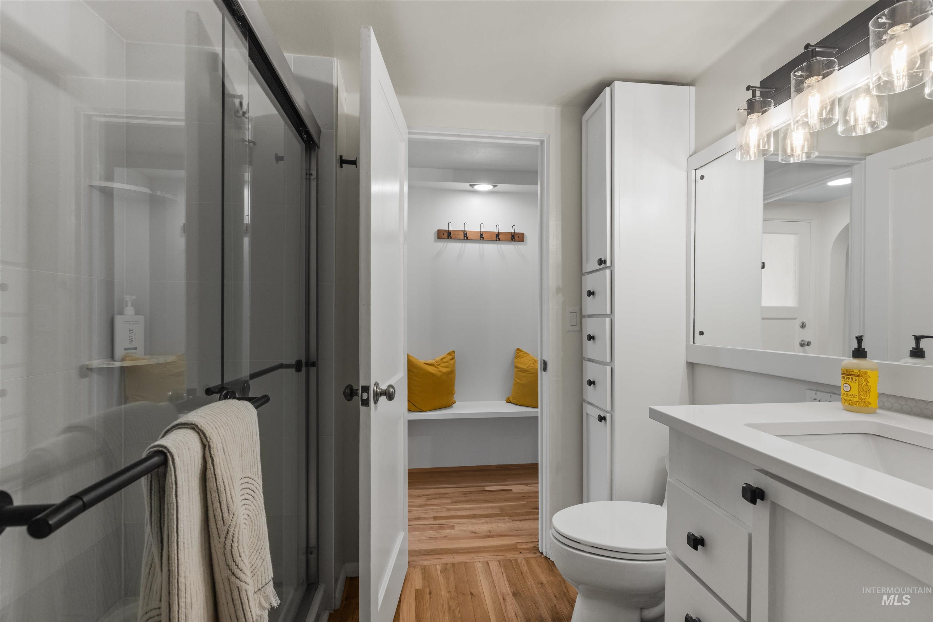 Bathroom featuring vanity, light wood finished floors, and a shower stall