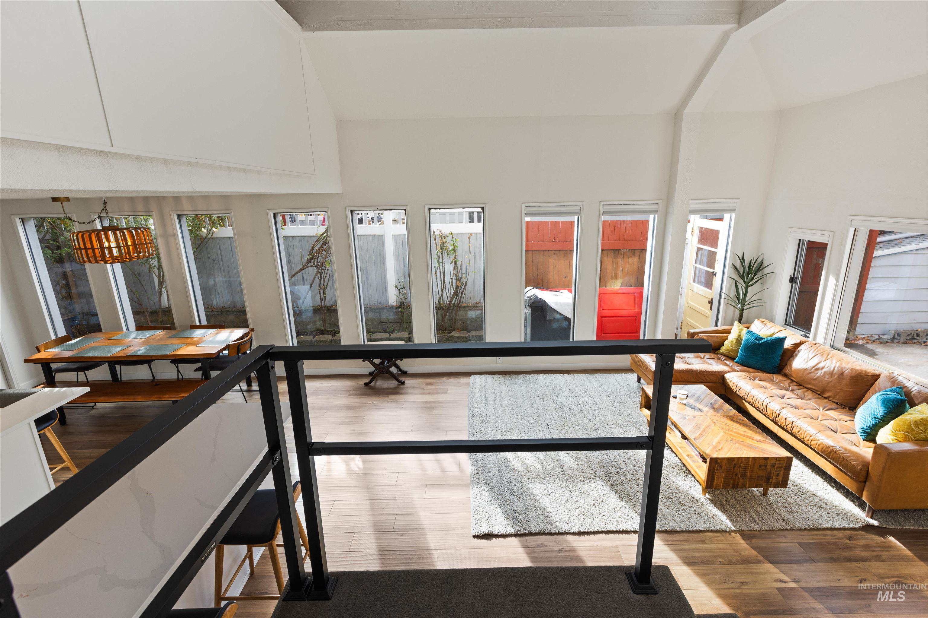 Living area with wood finished floors, high vaulted ceiling, and beamed ceiling