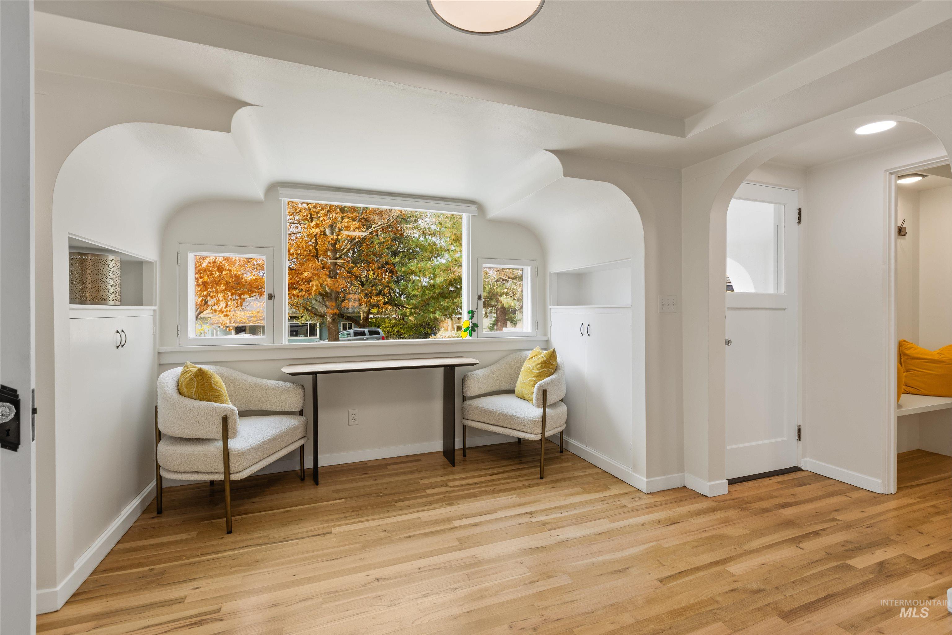 Living area featuring light wood-style flooring and arched walkways