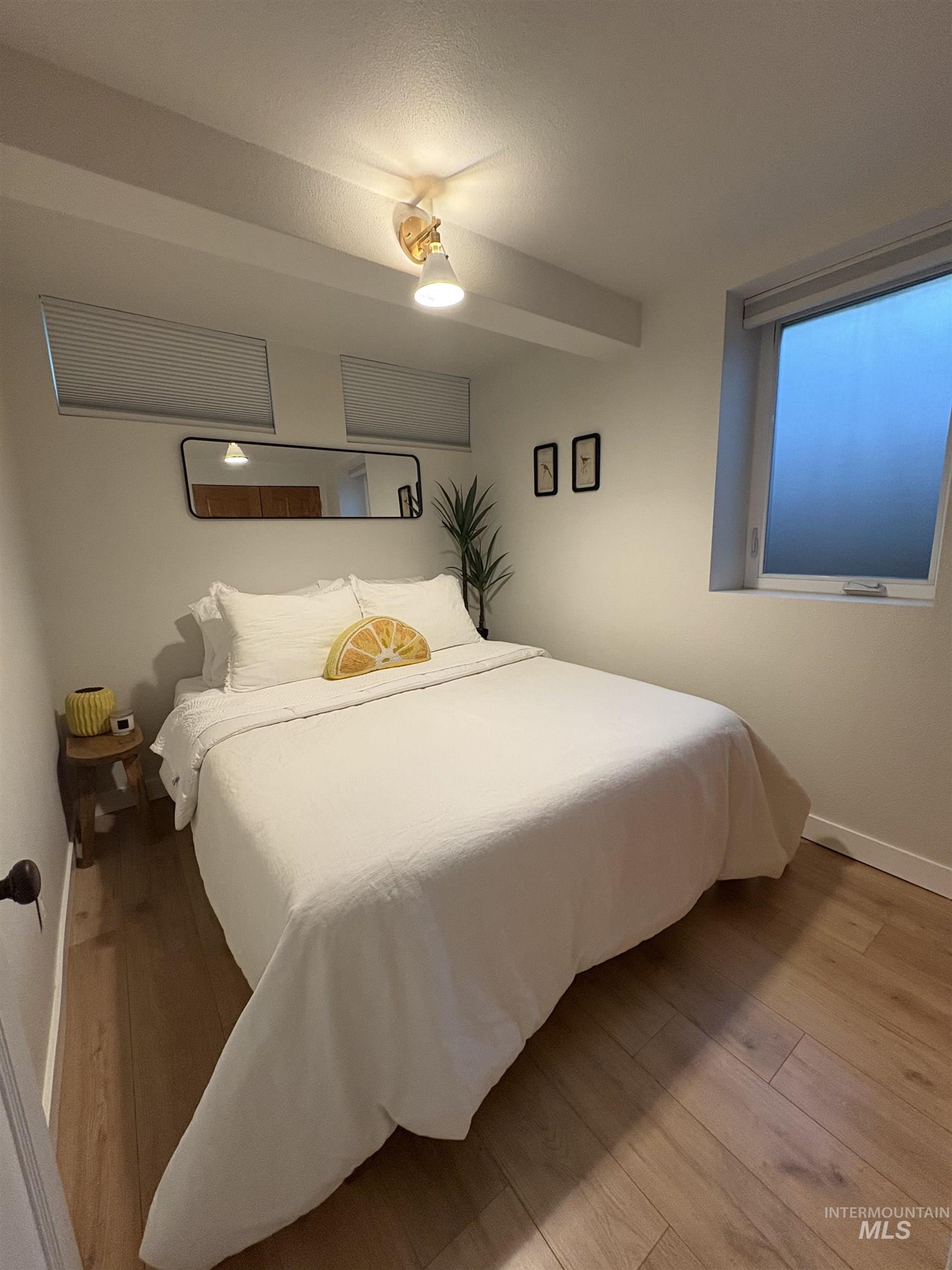 Bedroom with baseboards and wood finished floors