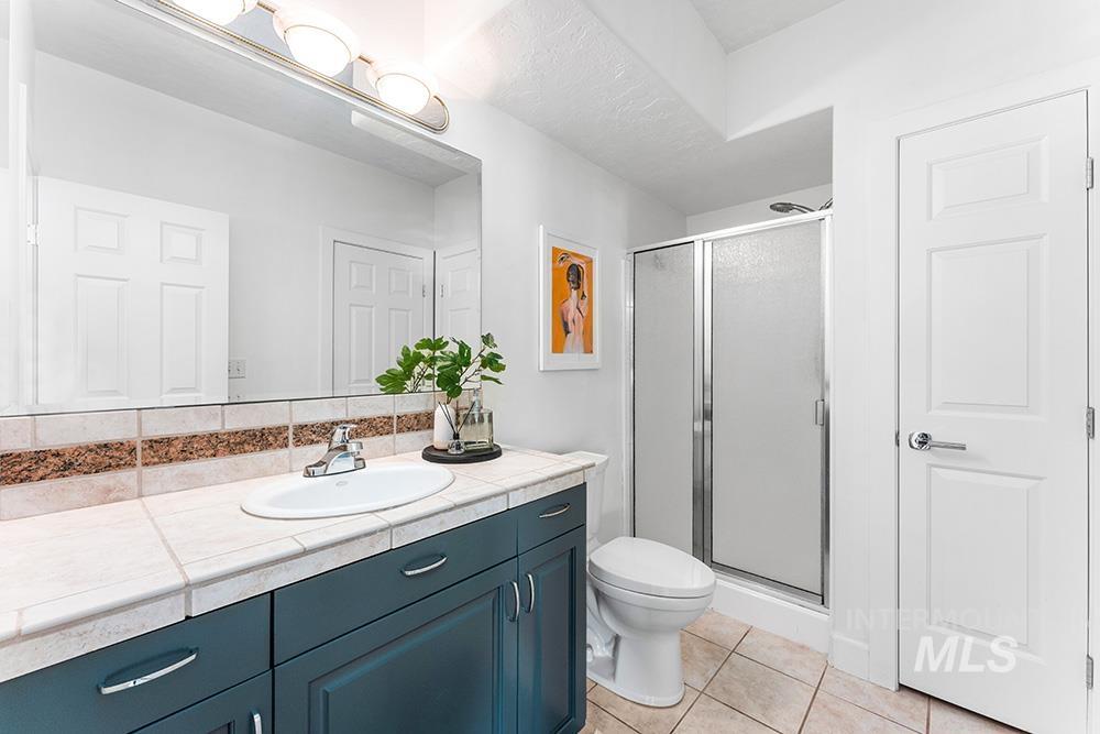 Bathroom featuring vanity, a stall shower, and tile patterned flooring