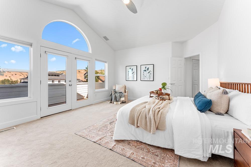 Bedroom with access to exterior, carpet, a ceiling fan, and high vaulted ceiling