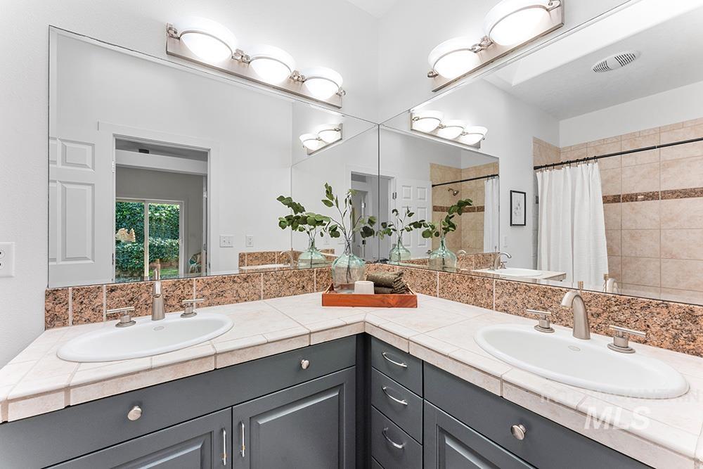 Full bath with double vanity and tiled shower