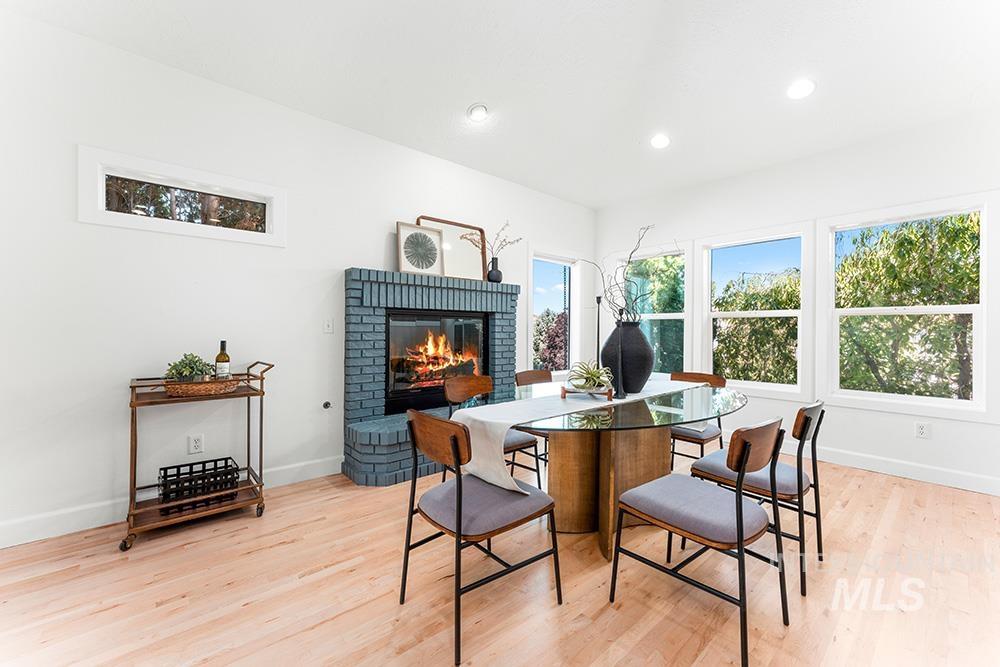 Dining room with a fireplace, light wood-style floors, and recessed lighting