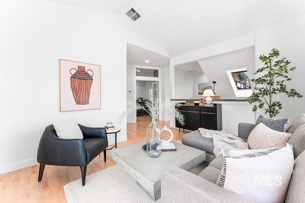 Living area with light wood-style floors and lofted ceiling