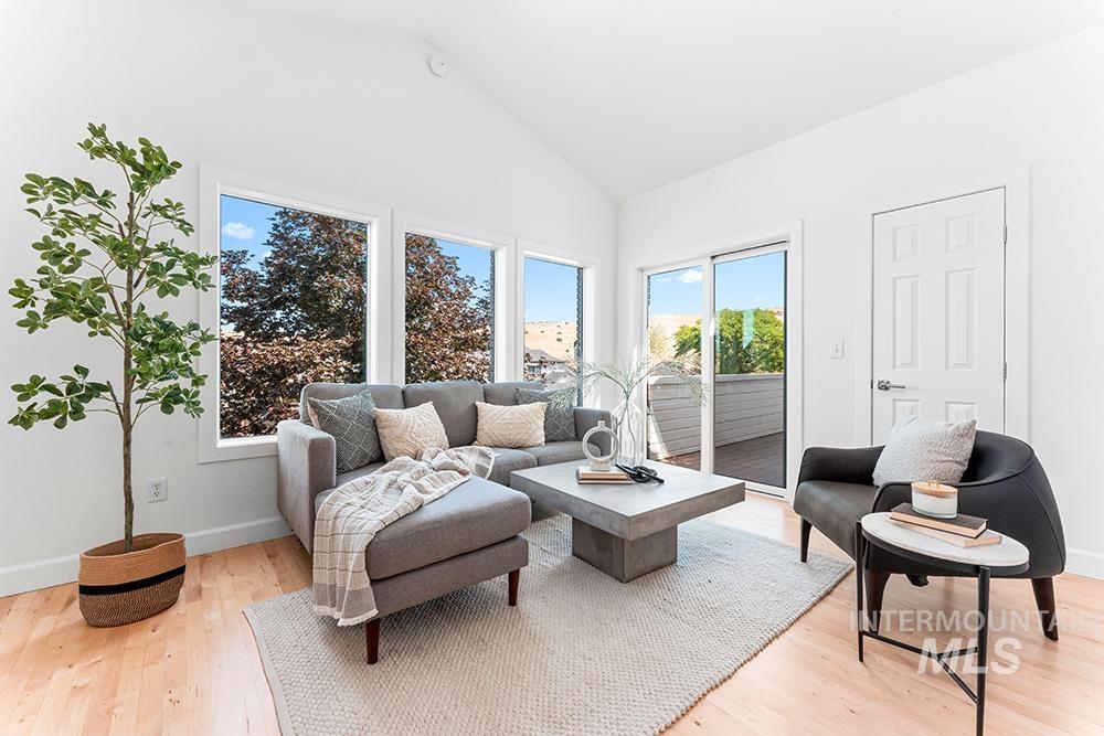 Living room with high vaulted ceiling and light wood-type flooring