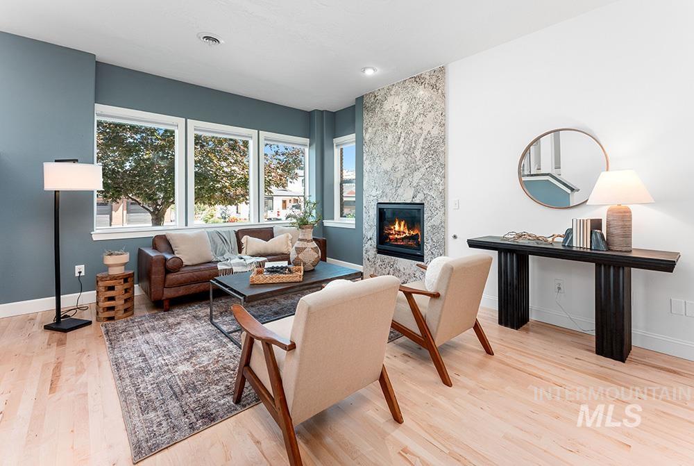 Living area with light wood finished floors and a tiled fireplace