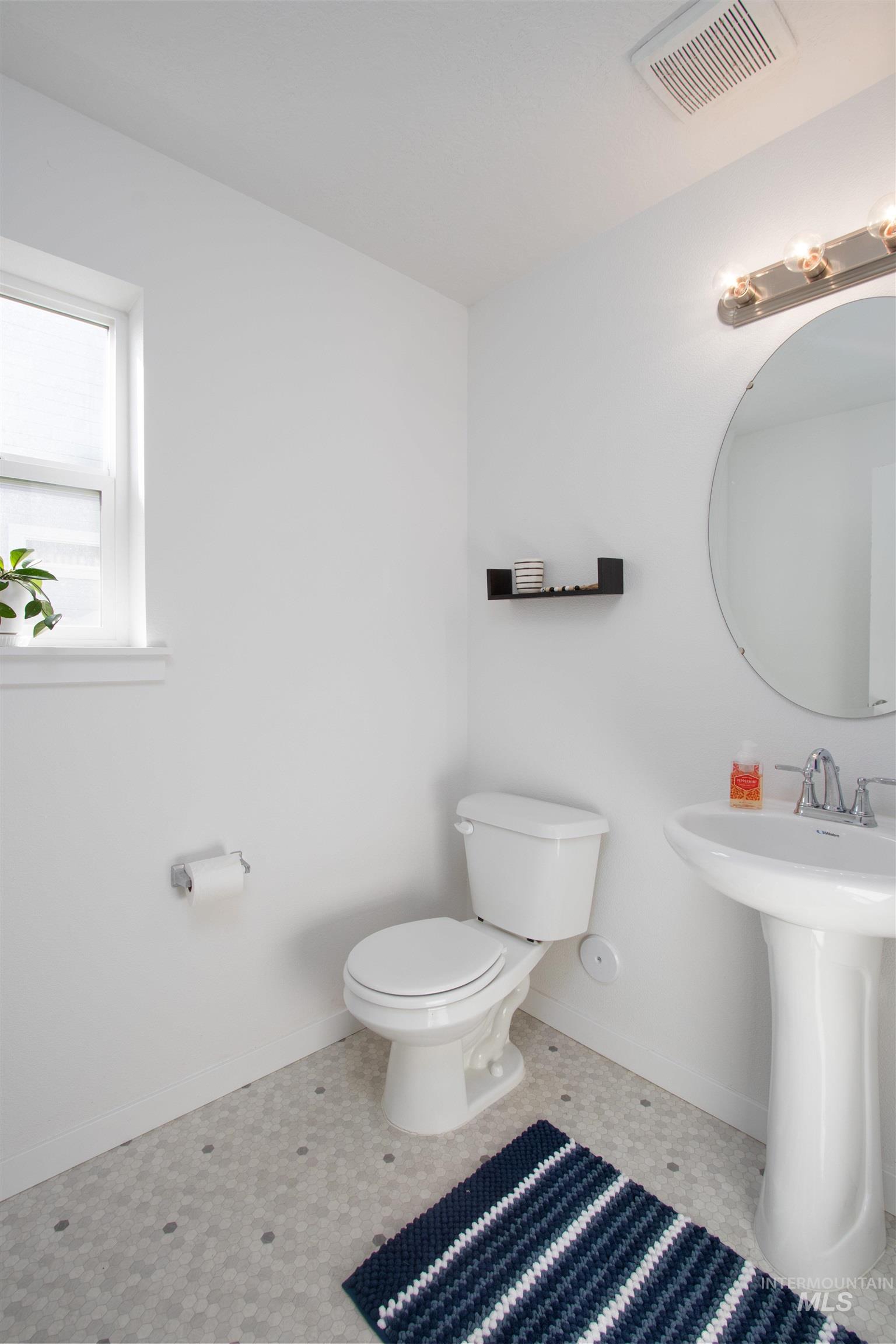 Half bathroom featuring toilet and baseboards