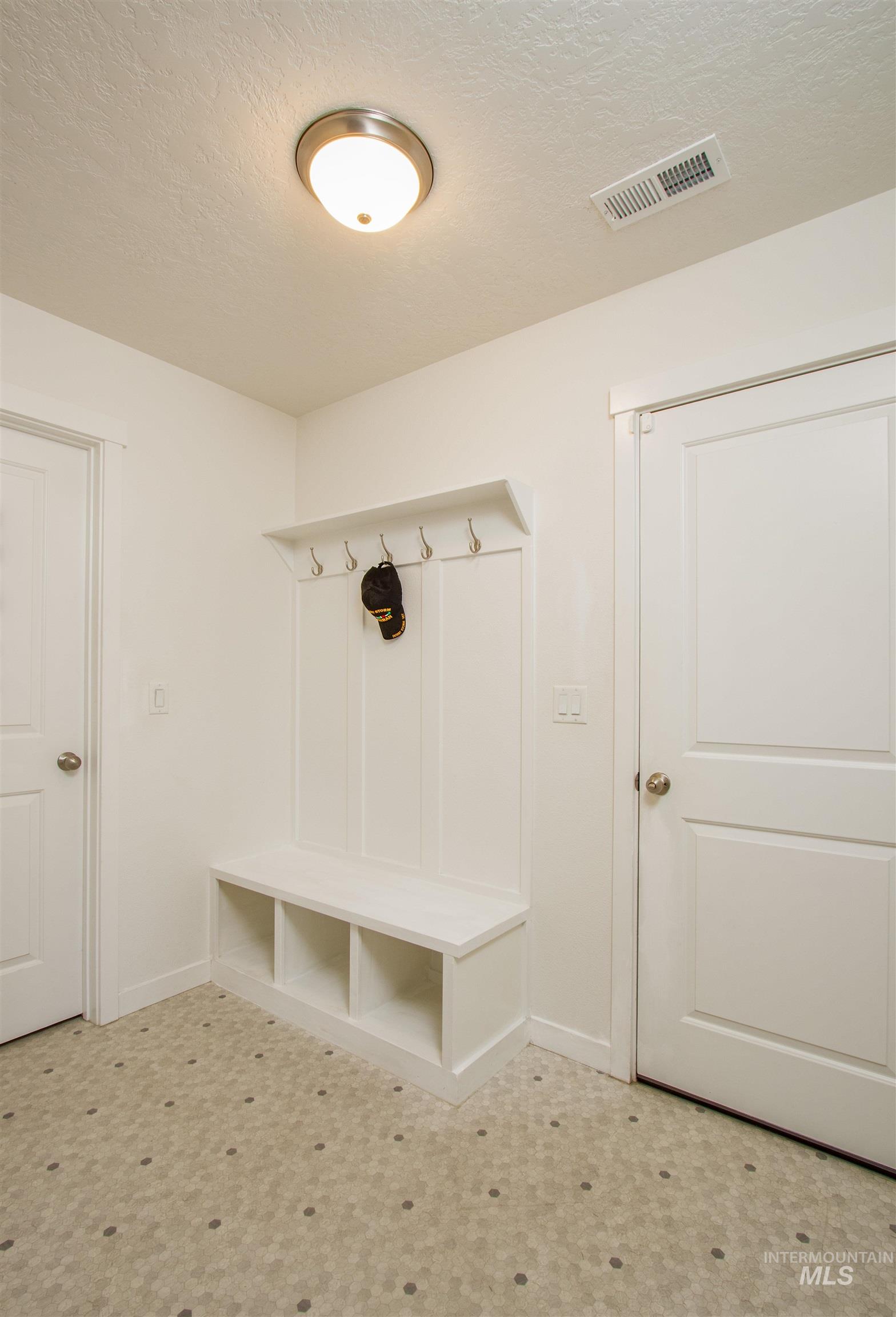 Mudroom featuring a textured ceiling and tile patterned floors
