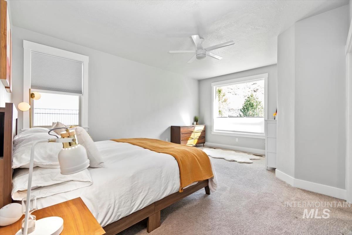 Bedroom with carpet, ceiling fan, and a textured ceiling