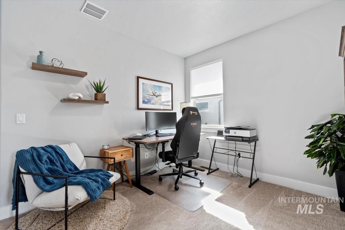 Office space with light colored carpet and baseboards