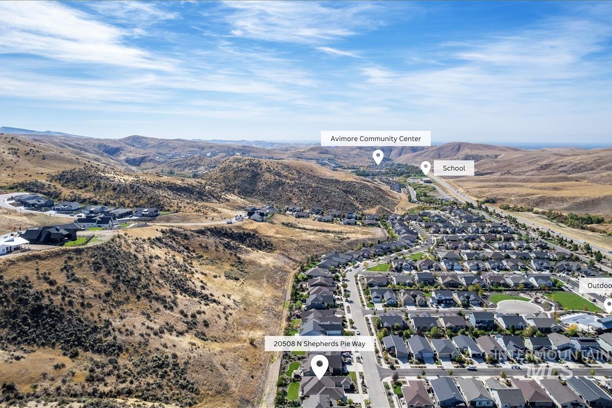 Aerial view of property's location featuring nearby suburban area and mountains