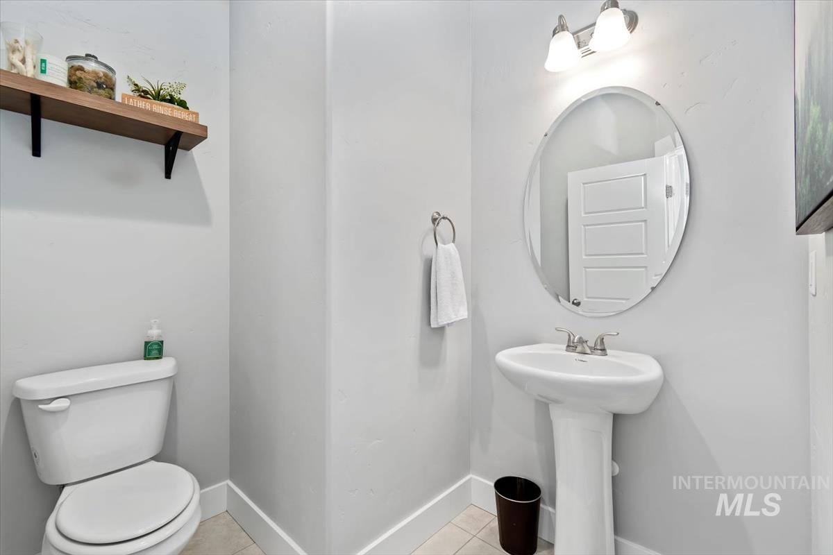 Half bath with light tile patterned floors and toilet