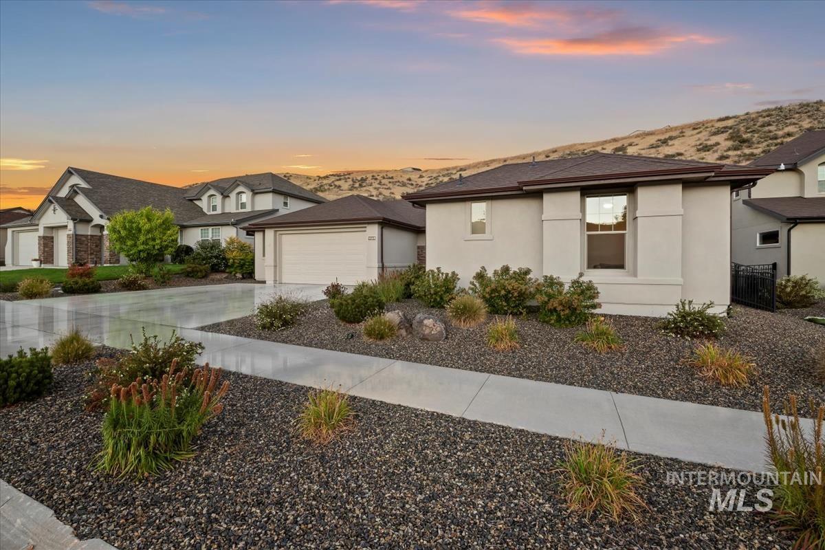View of front of property with stucco siding, driveway, and a mountain view