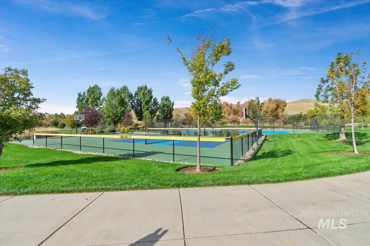View of swimming pool with a tennis court and a mountain view