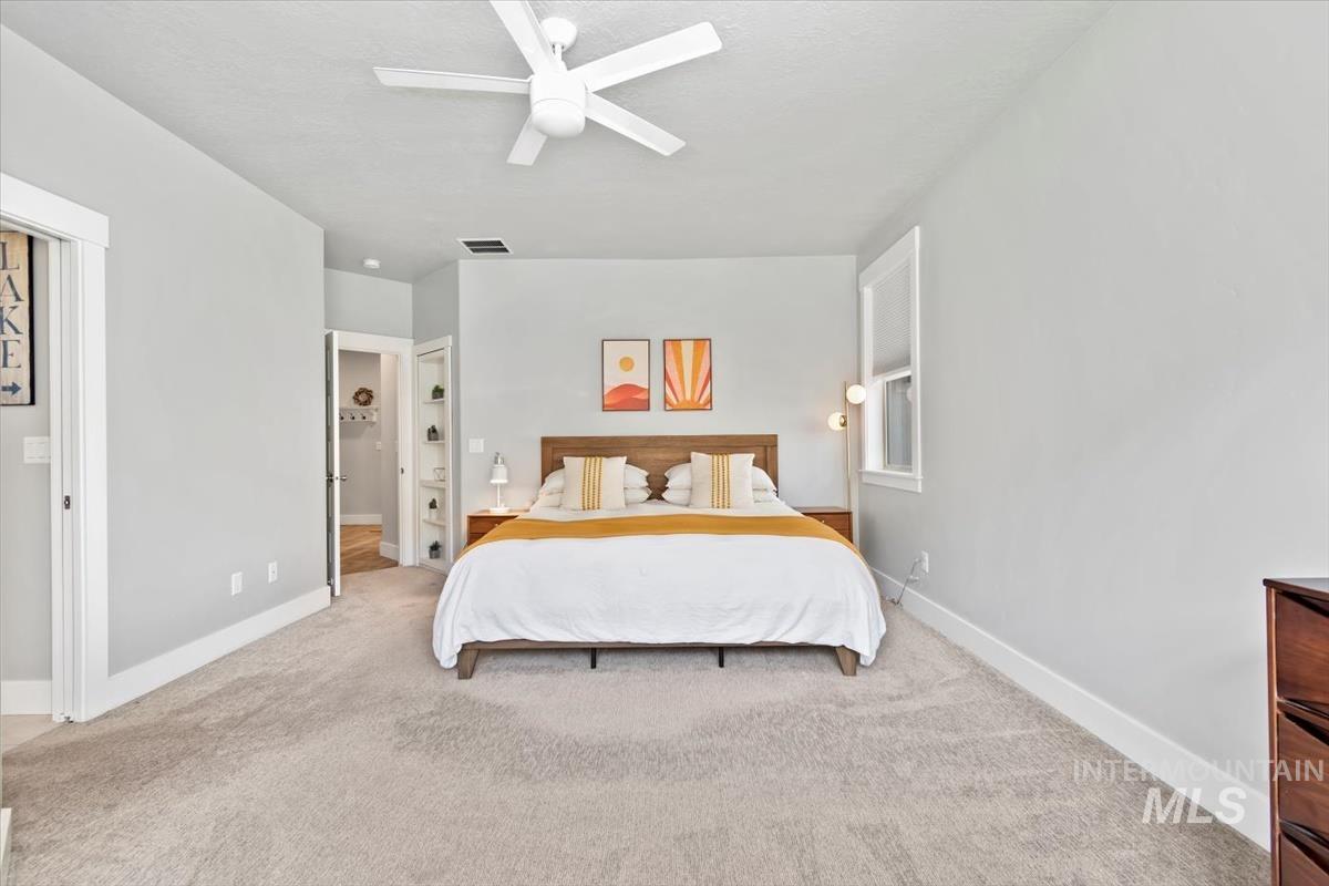 Carpeted bedroom with baseboards and a ceiling fan