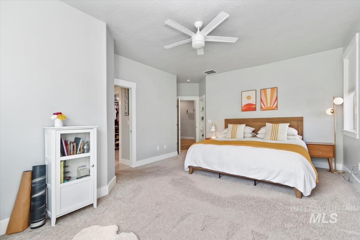 Carpeted bedroom with baseboards and a ceiling fan