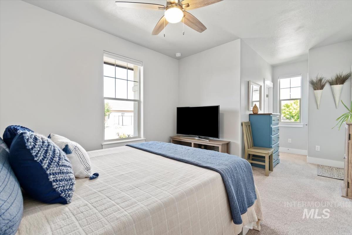 Bedroom with light carpet and a ceiling fan