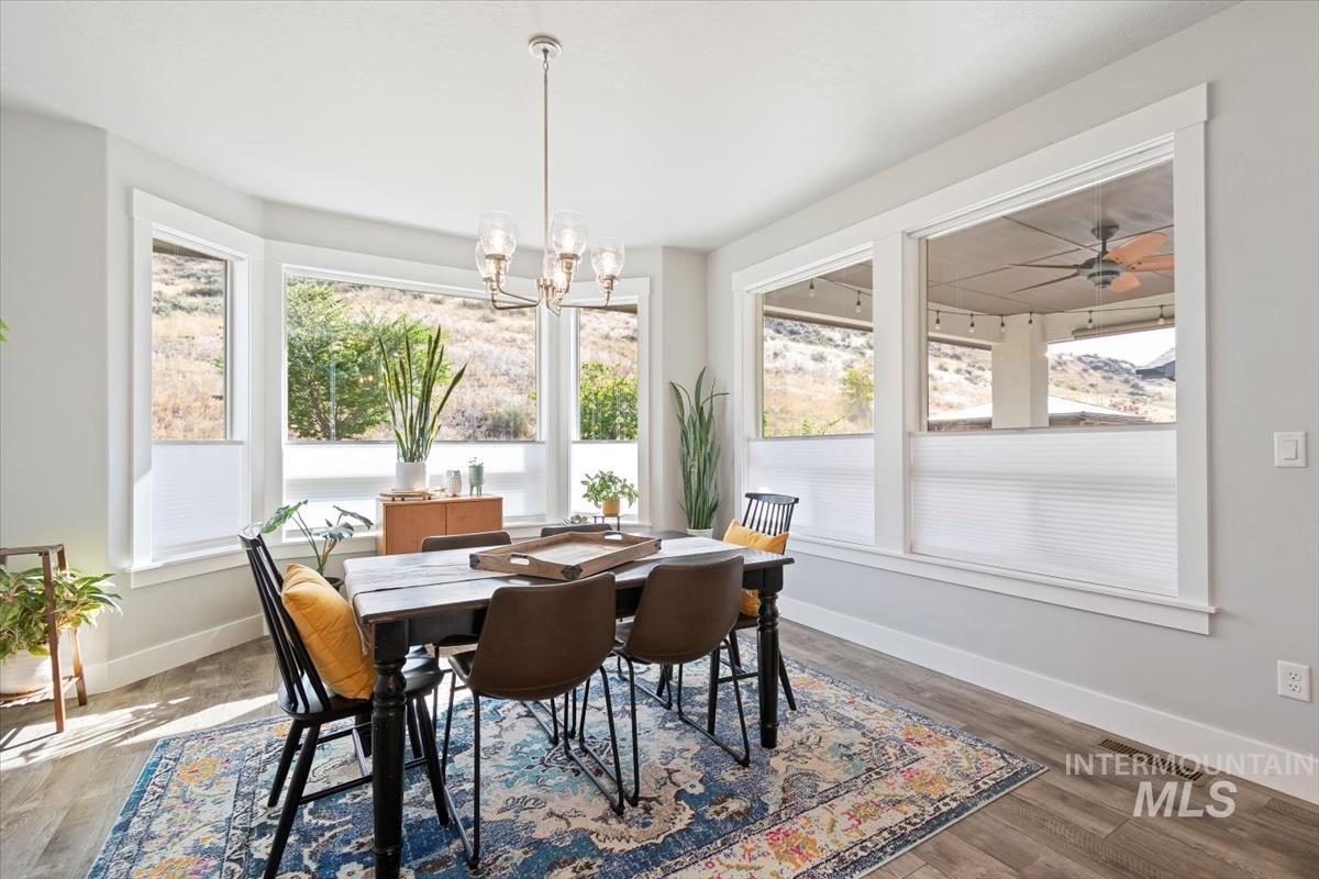 Dining space with plenty of natural light, wood finished floors, and a chandelier