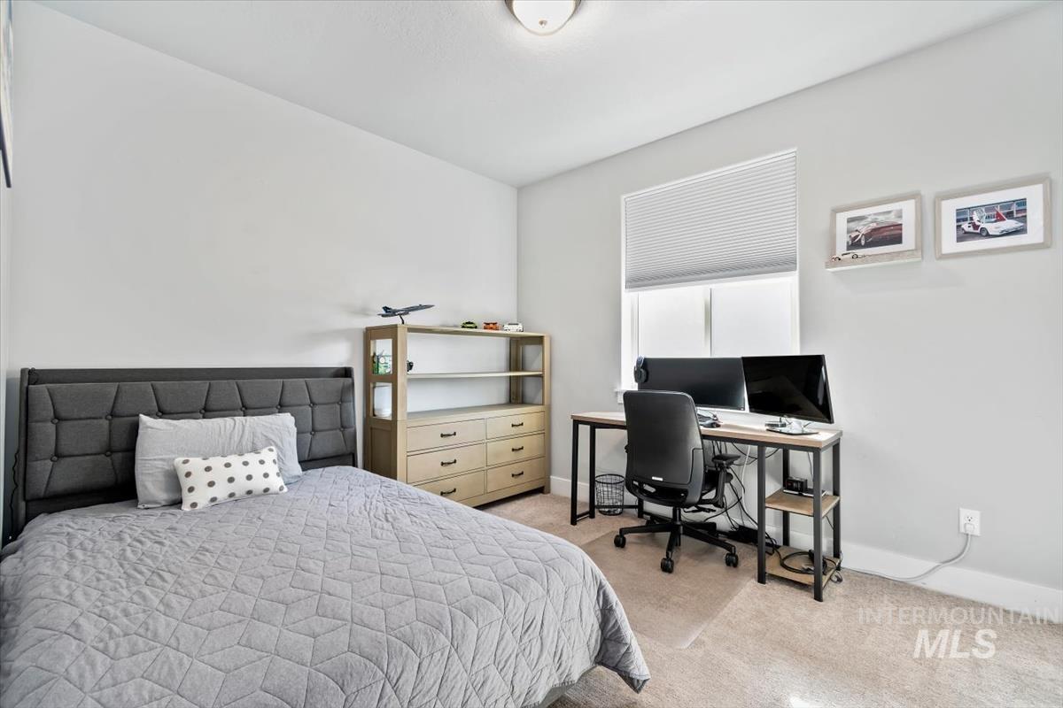 Bedroom with light carpet and a desk