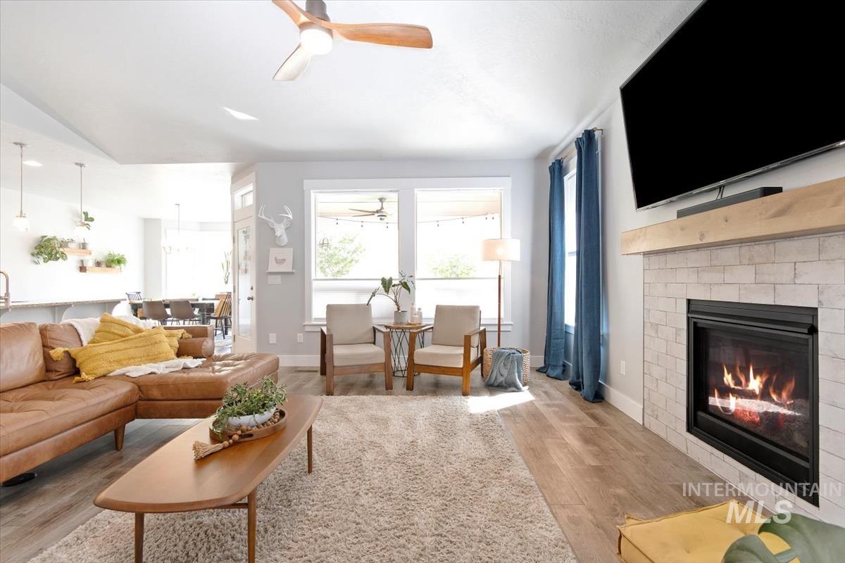 Living area featuring ceiling fan, wood finished floors, and a fireplace