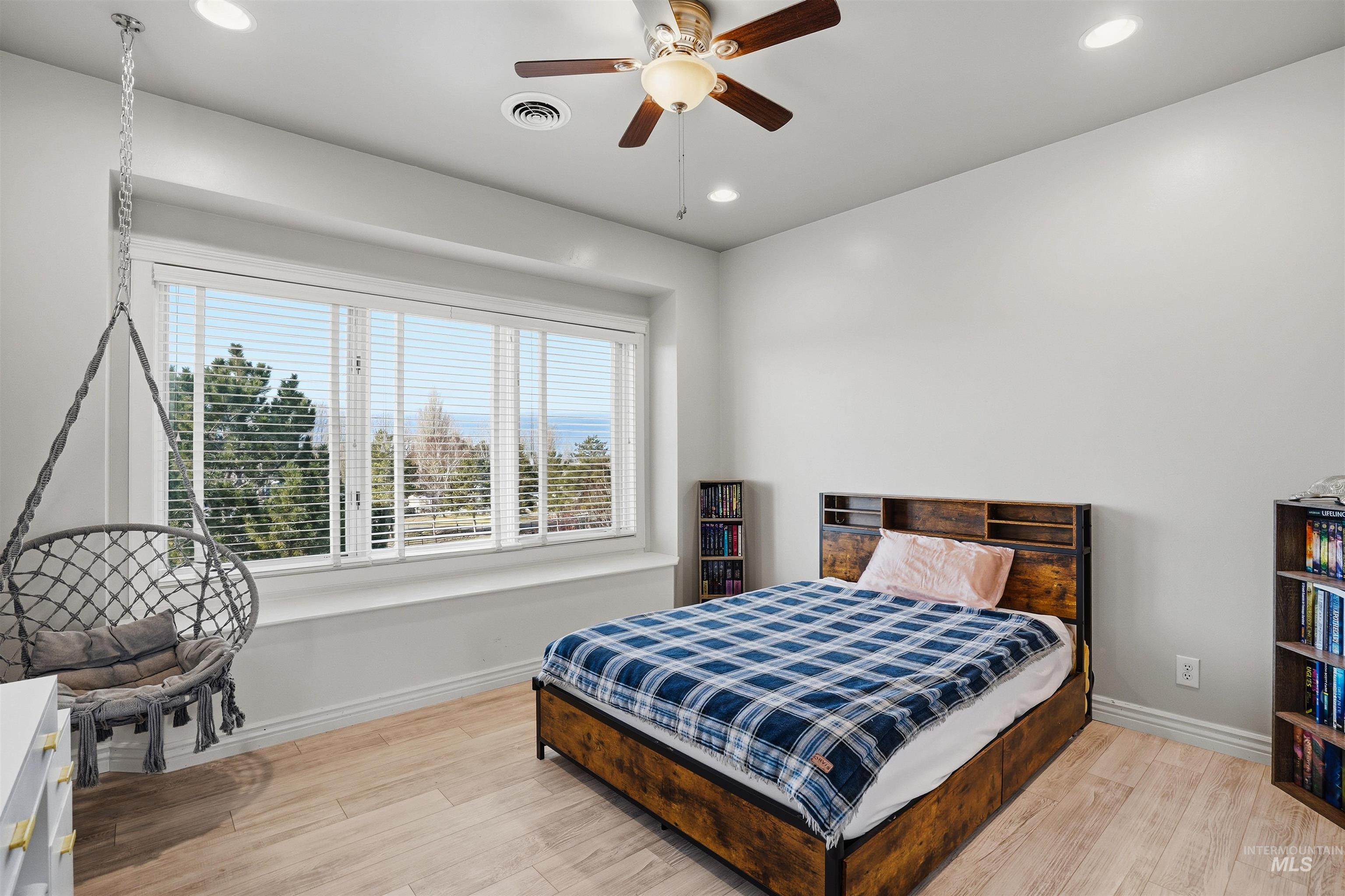 Bedroom featuring light wood-type flooring, a ceiling fan, and recessed lighting