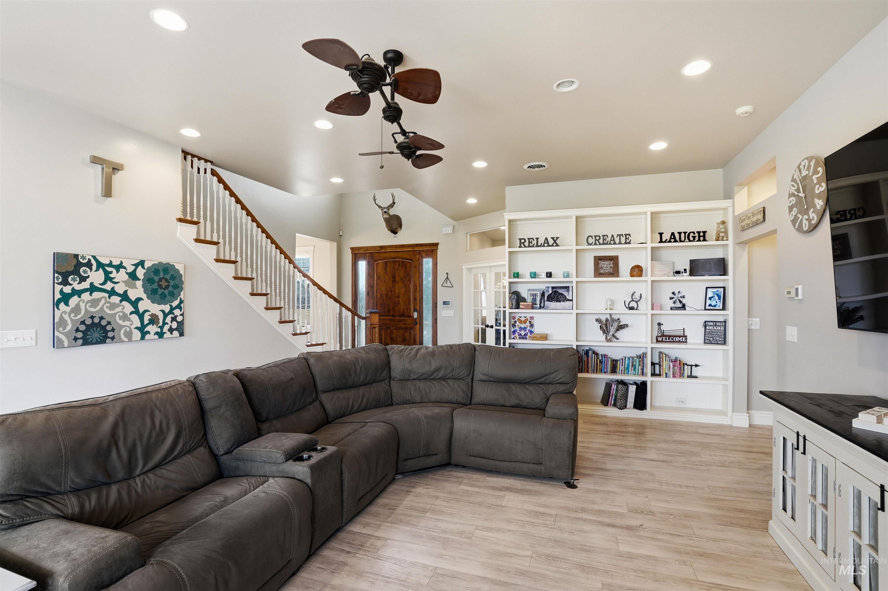 Living area with light wood-type flooring, recessed lighting, and a ceiling fan