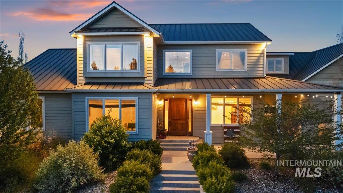 View of front facade featuring a standing seam roof and a porch