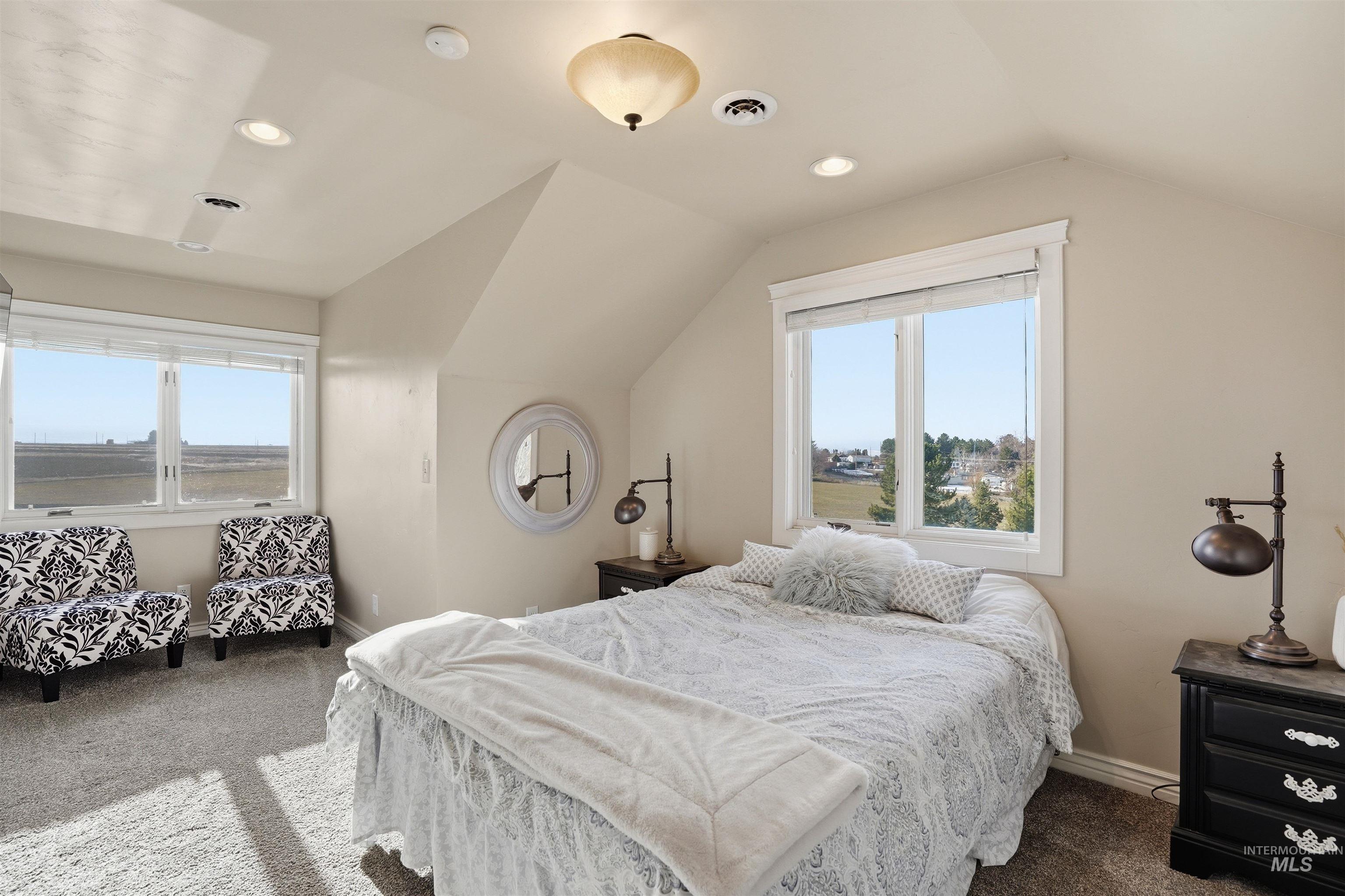 Carpeted bedroom with lofted ceiling, multiple windows, and recessed lighting