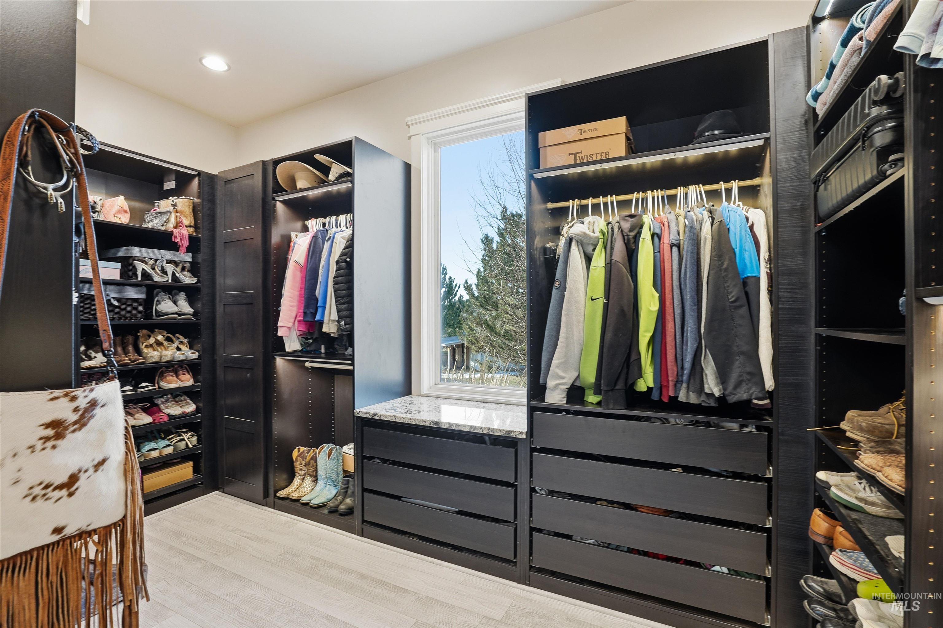 Walk in closet with light wood-type flooring