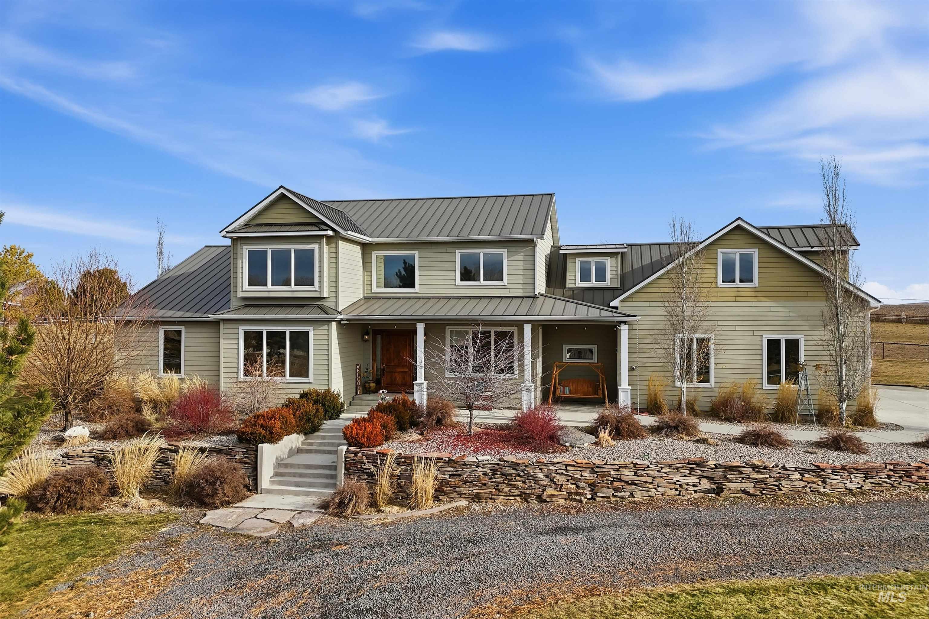 View of front facade with covered porch and a standing seam roof