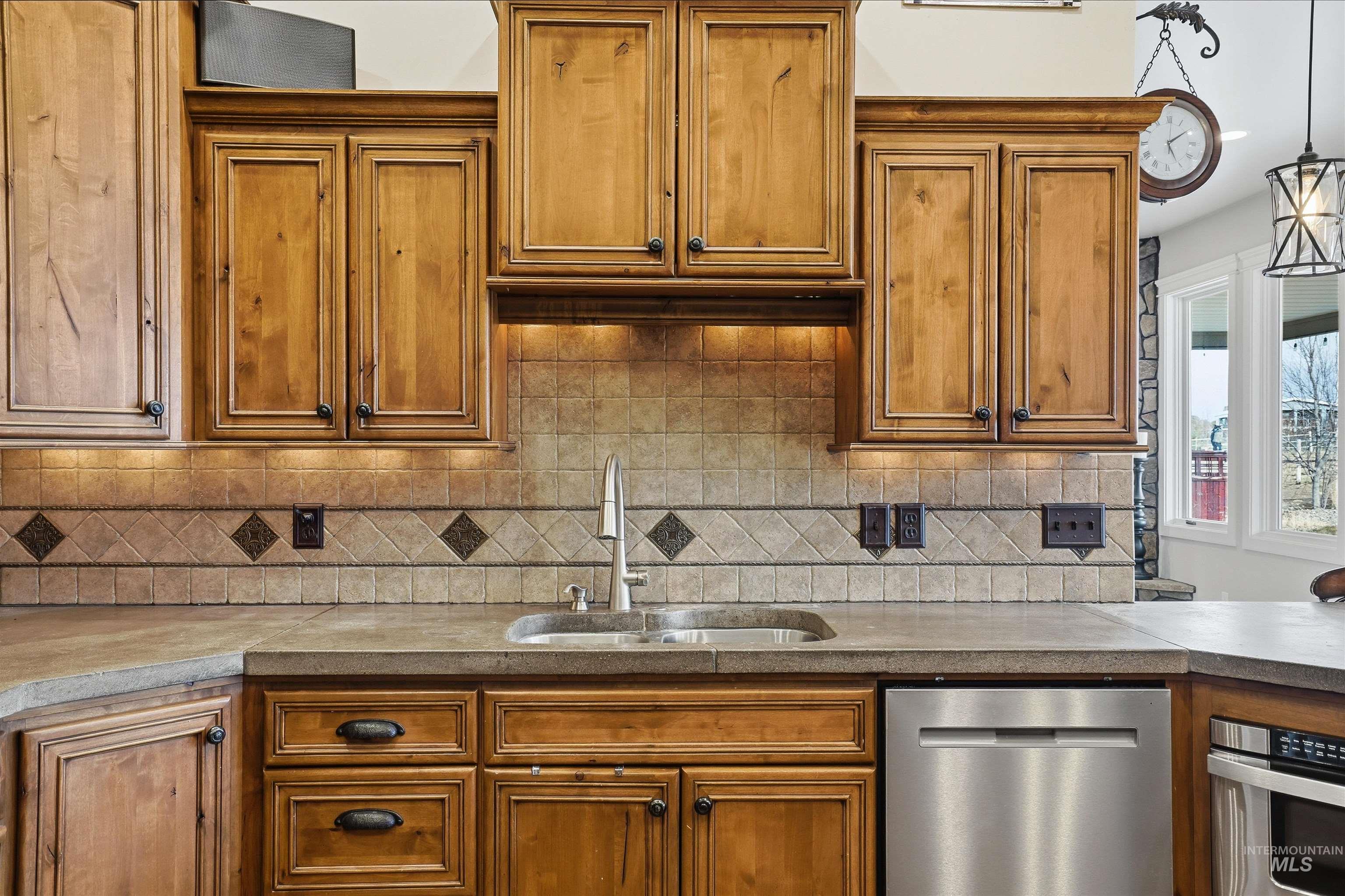 Kitchen with wood finish cabinets, stainless steel appliances, and light countertops