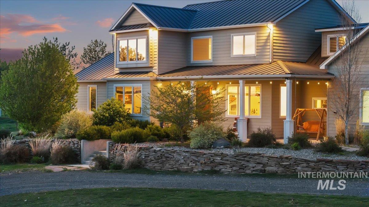 View of front facade featuring a standing seam roof and a porch
