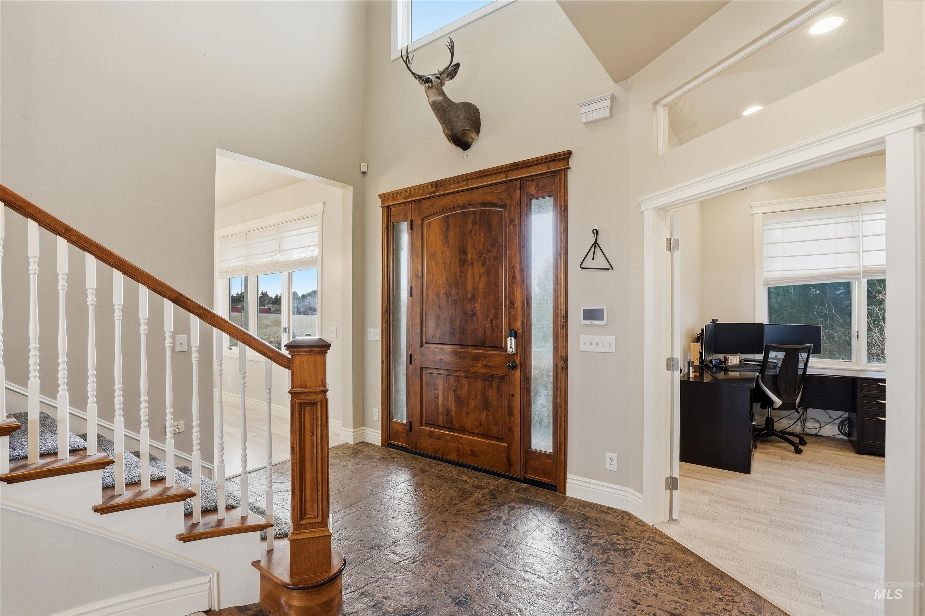 Entrance foyer with a high ceiling and light stone finish floors
