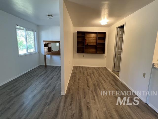 Hall featuring dark wood-style floors and baseboards