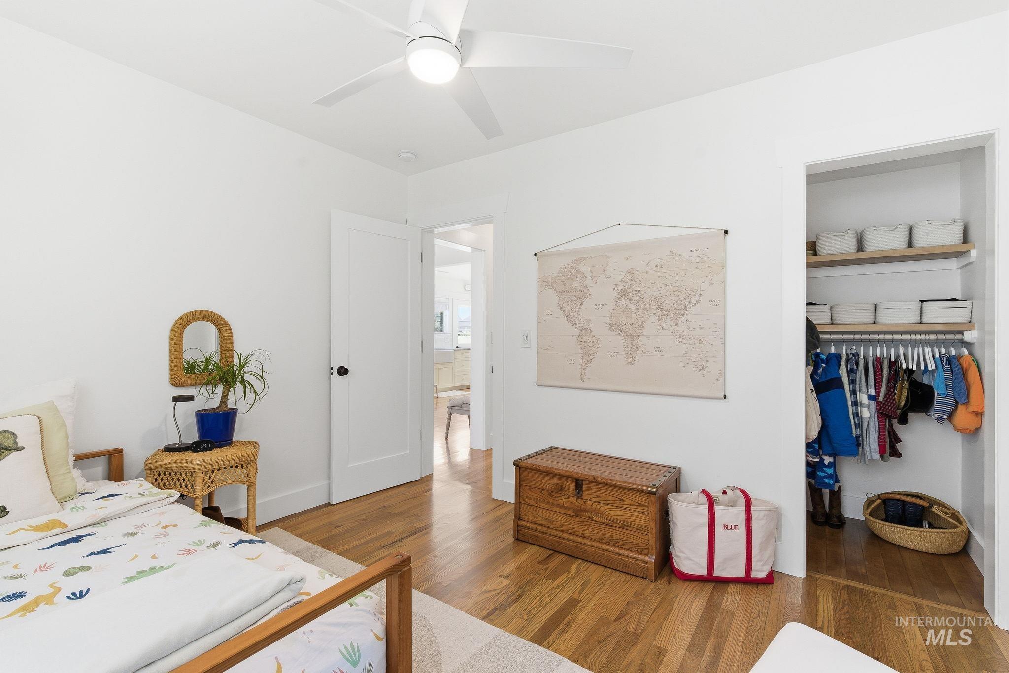 Bedroom featuring wood finished floors, a ceiling fan, and a spacious closet
