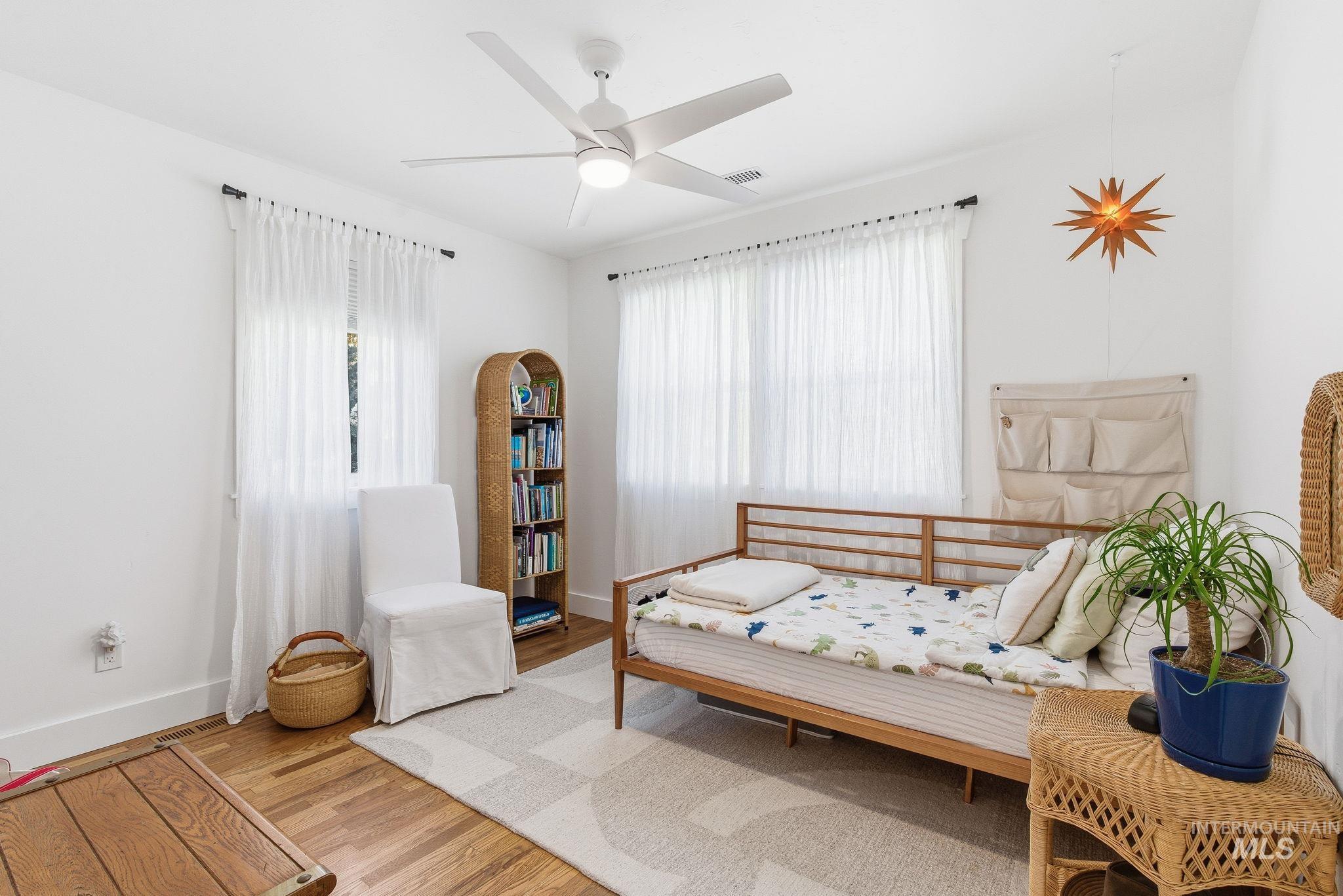 Sitting room with wood finished floors, plenty of natural light, and ceiling fan