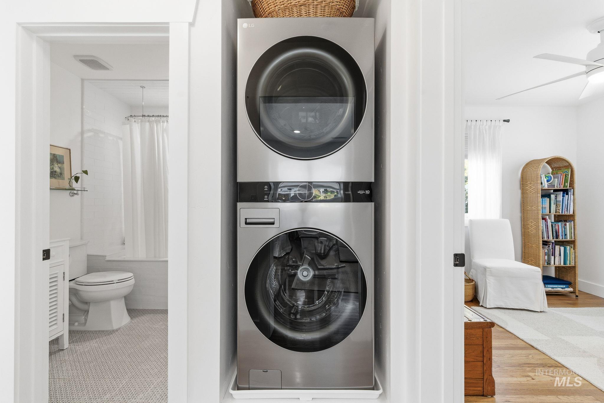 Laundry room with stacked washer / drying machine and ceiling fan
