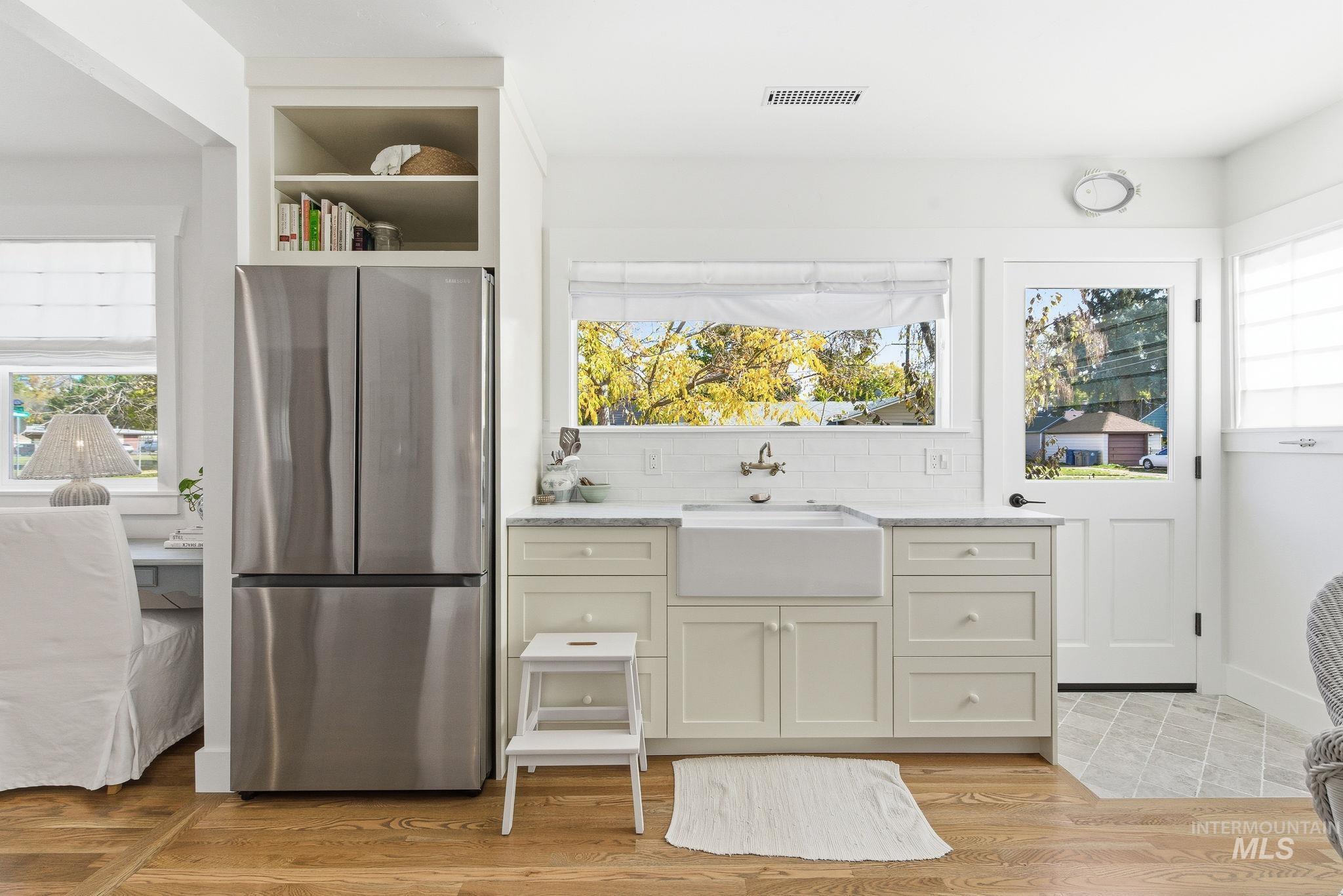 Kitchen with freestanding refrigerator, tasteful backsplash, and plenty of natural light