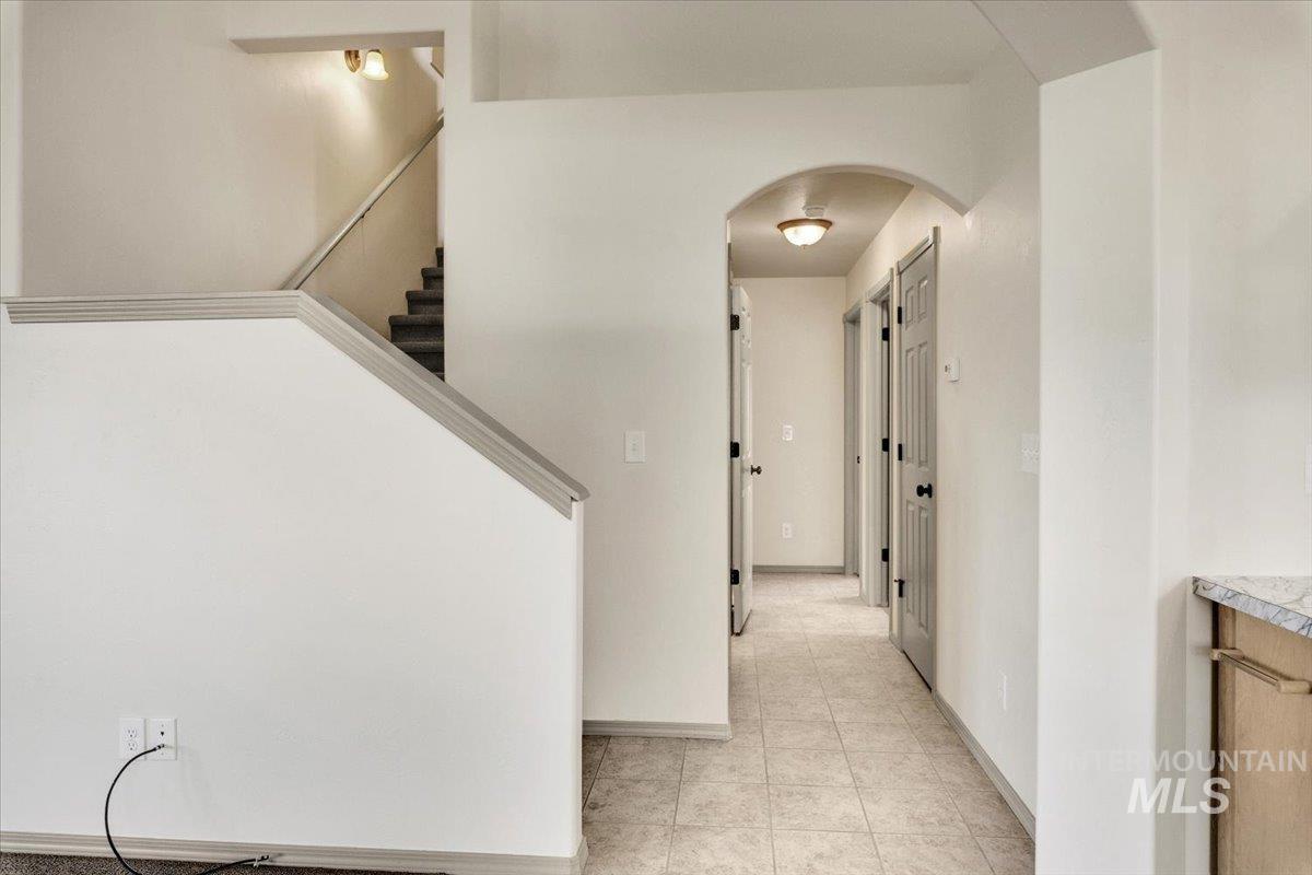 Hall with arched walkways and light tile patterned floors