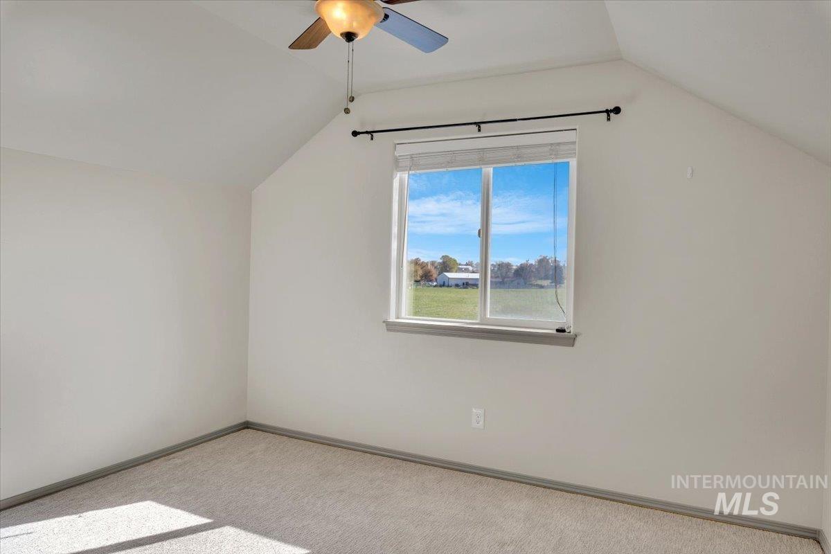 Additional living space with light colored carpet and ceiling fan